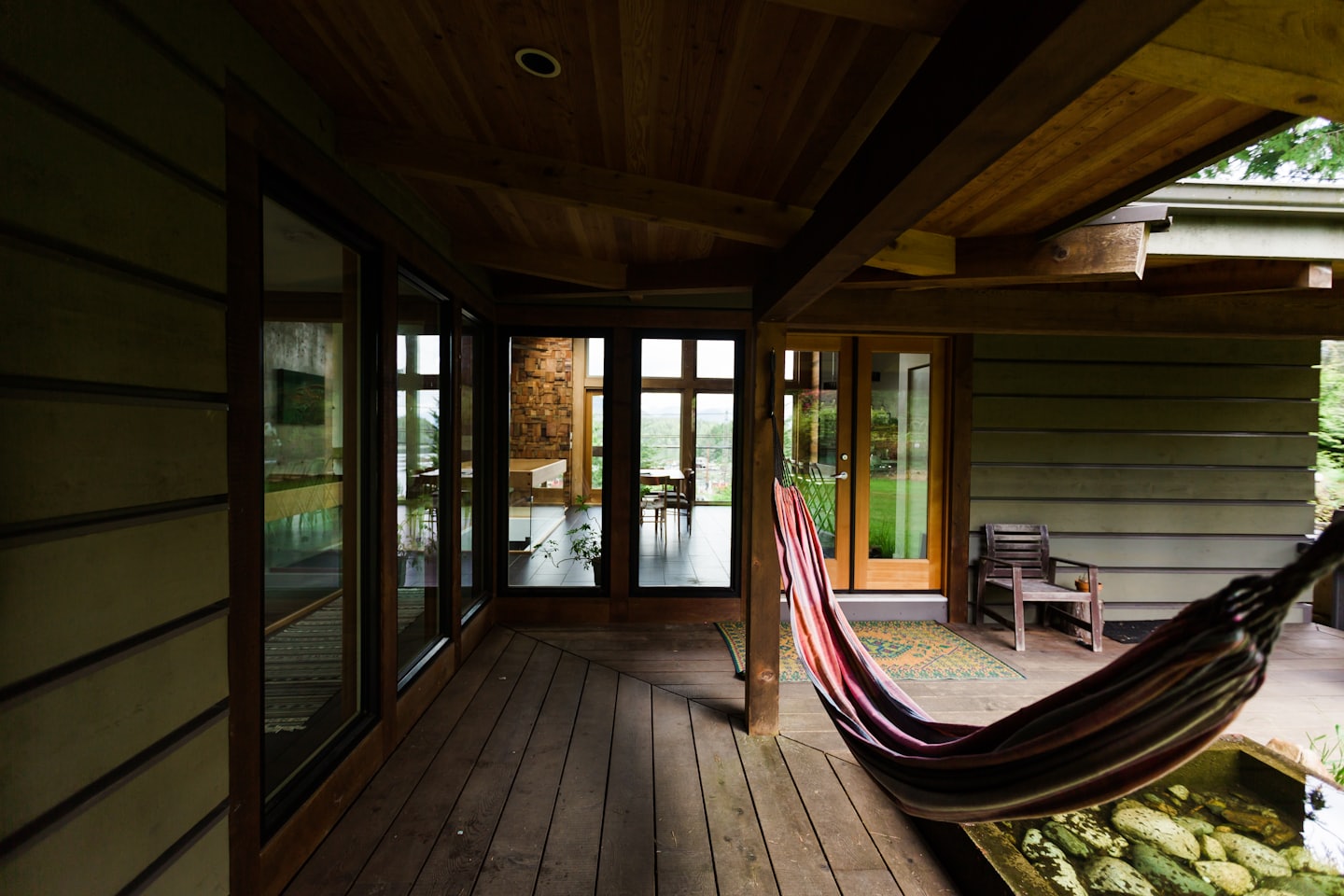 Colorful striped hammock hanging on a modern wooden deck.